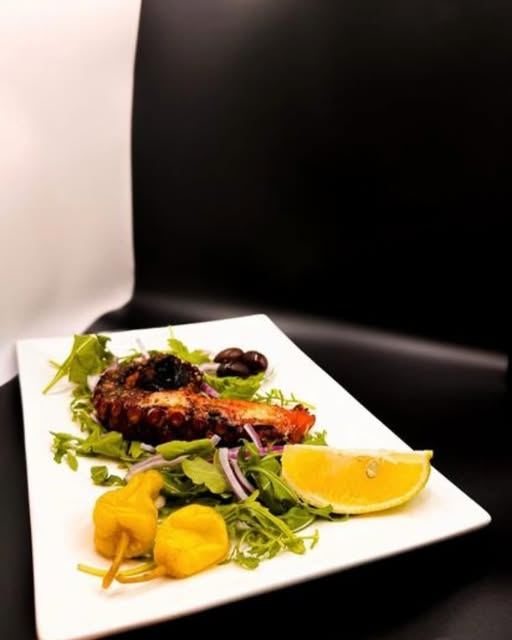 Grilled octopus with arugula, peppers and lemon