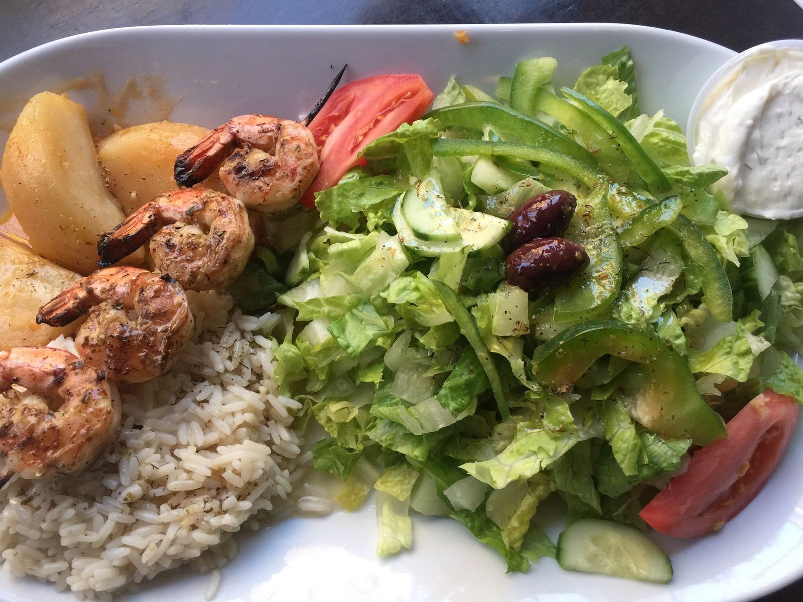 Shrimp skewer with rice and Greek salad